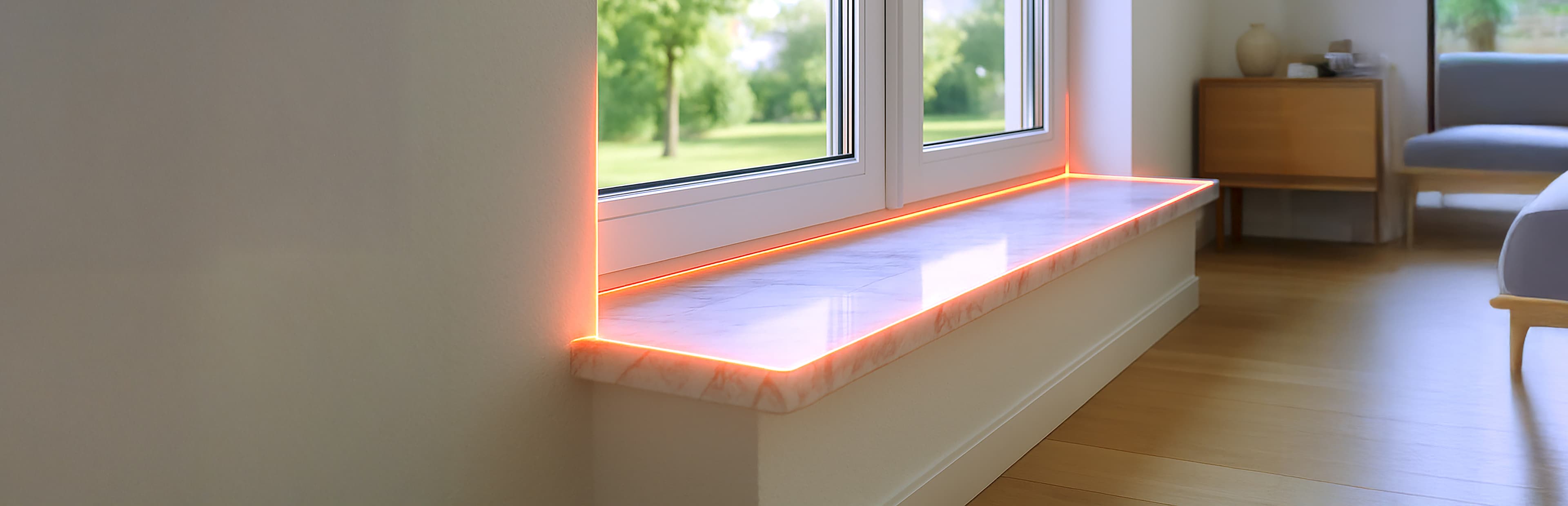 Ein modernes Wohnzimmer mit einem großen Fenster und einer Fensterbank aus Marmor, die von einer sanften orangefarbenen LED-Beleuchtung an den Rändern beleuchtet wird. Holzböden und minimale Möbel sind zu sehen, vor dem Fenster ist Grün zu sehen.