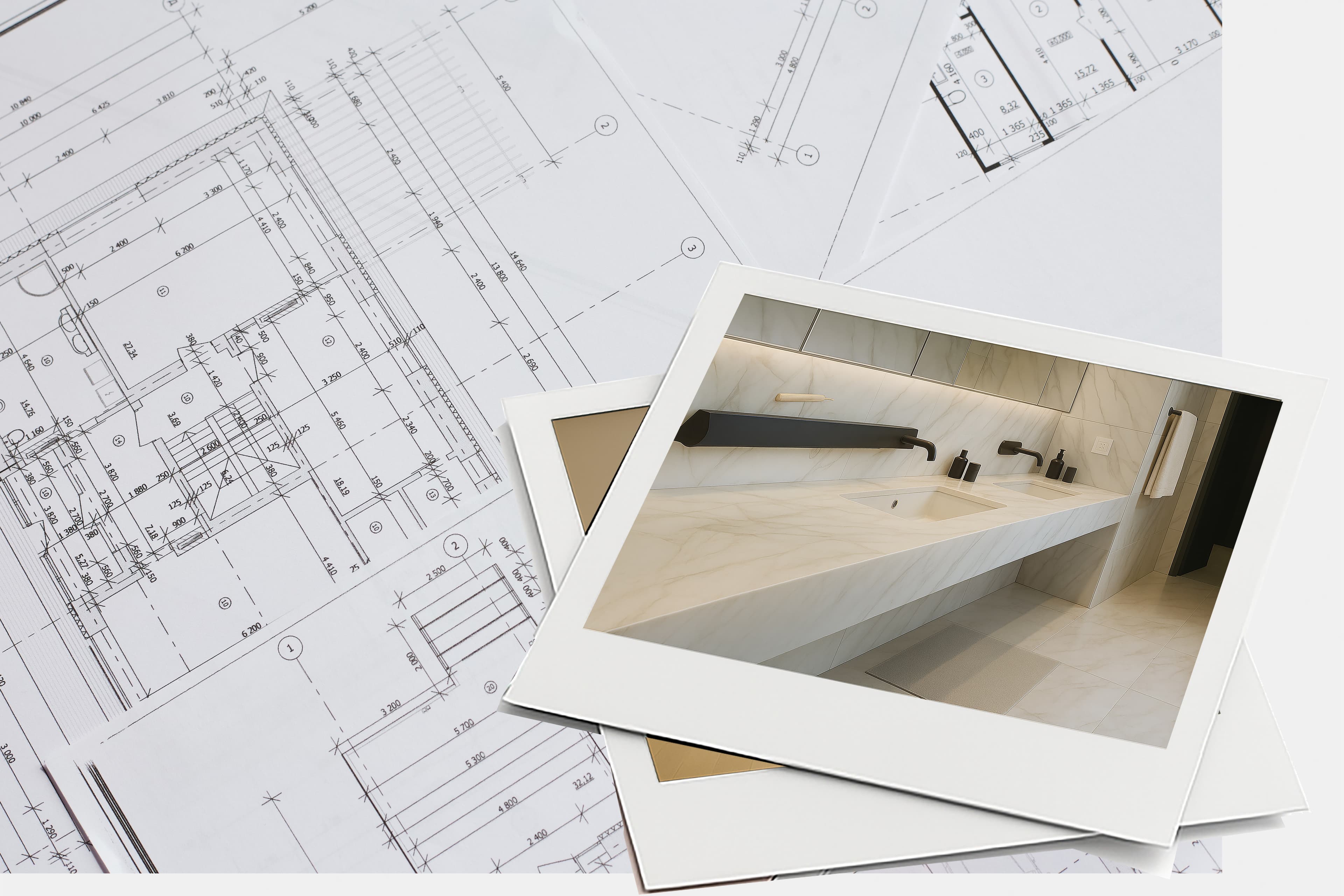 Photo of a modern bathroom with a marble sink placed on top of architectural blueprints, suggesting a connection between interior design and construction planning.